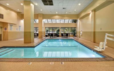 Relaxing indoor pool with seating area at Embassy Suites By Hilton Santa Clara Silicon Valley.