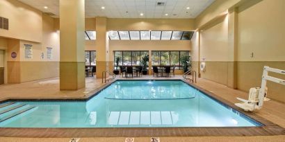 Relaxing indoor pool with seating area at Embassy Suites By Hilton Santa Clara Silicon Valley.