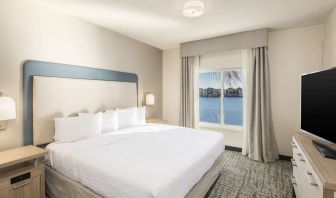 King bed with TV and a view of the Blue Lagoon at Homewood Suites By Hilton Miami Airport-Blue Lagoon.