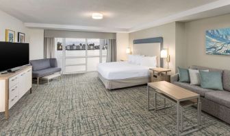 Spacious day use room with sofa and a view of the Blue Lagoon at Homewood Suites By Hilton Miami Airport-Blue Lagoon.