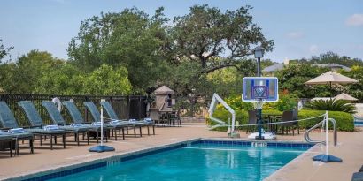 One of the 3 outdoor pools with loungers at Hilton San Antonio Hill Country.