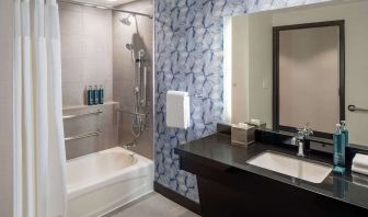 Guest bathroom with shower and tub at Hilton San Antonio Hill Country.