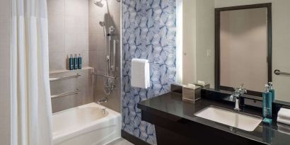 Guest bathroom with shower and tub at Hilton San Antonio Hill Country.