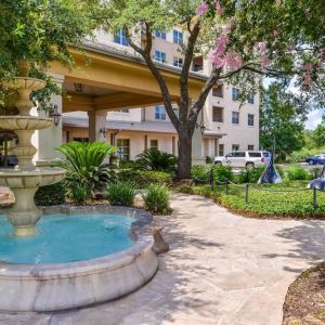 Hotel facade and the parking area at Hilton San Antonio Hill Country.