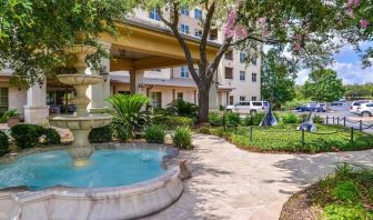 Hotel facade and the parking area at Hilton San Antonio Hill Country.