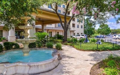 Hotel facade and the parking area at Hilton San Antonio Hill Country.