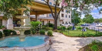 Hotel facade and the parking area at Hilton San Antonio Hill Country.