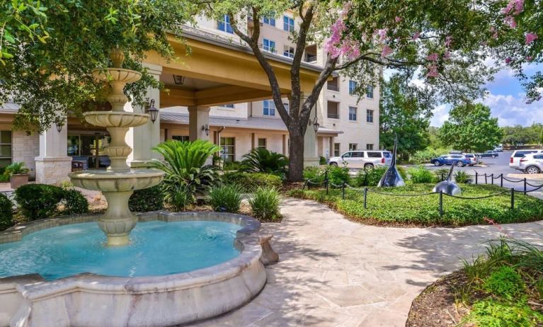Hotel facade and the parking area at Hilton San Antonio Hill Country.