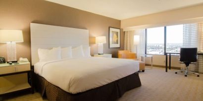 Delux king room with work desk and natural light at Hilton Los Angeles Airport.