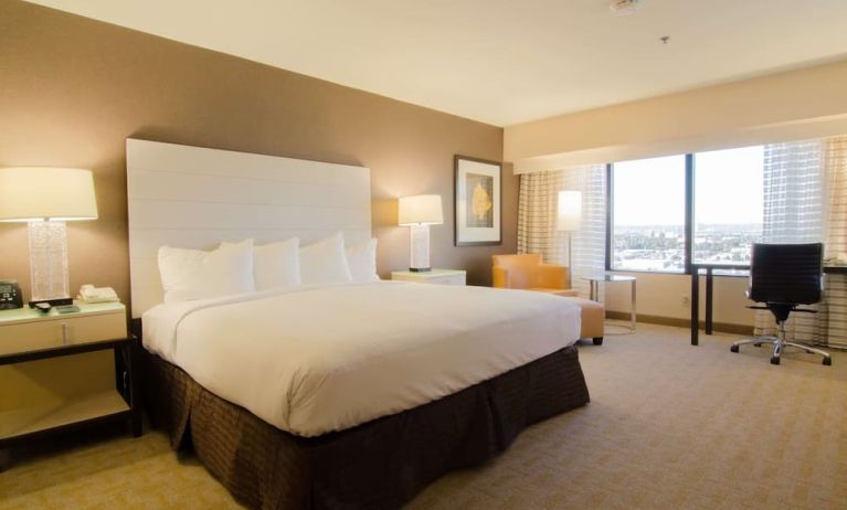 Delux king room with work desk and natural light at Hilton Los Angeles Airport.