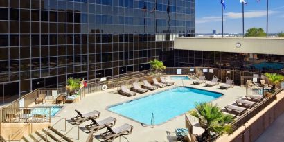 Stunning outdoor pool surrounded by loungers at Hilton Los Angeles Airport.