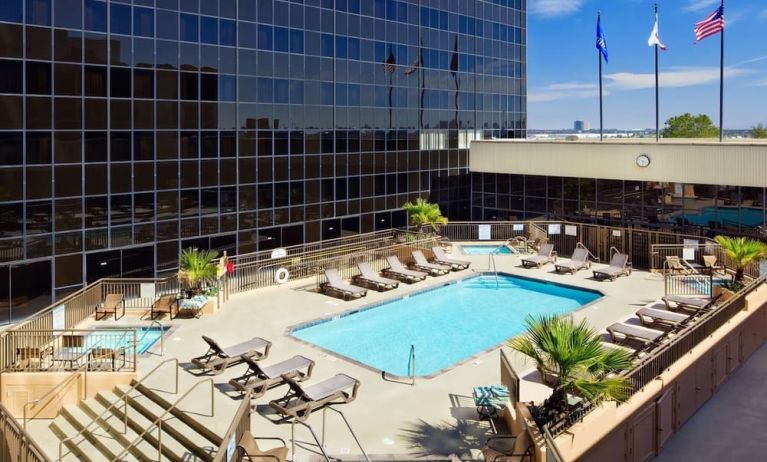 Stunning outdoor pool surrounded by loungers at Hilton Los Angeles Airport.