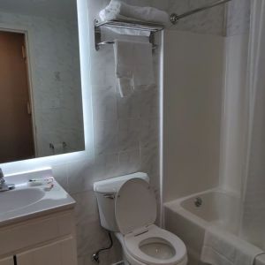 Guest bathroom with shower and tub at Hotel Key.