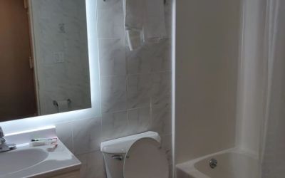 Guest bathroom with shower and tub at Hotel Key.