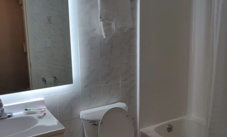 Guest bathroom with shower and tub at Hotel Key.