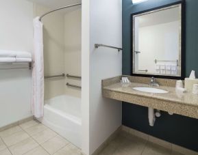 Private guest bathroom with combined shower and tub at Hilton Garden Inn Dothan.