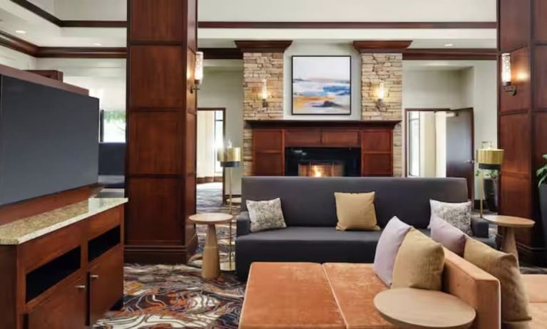 Lobby lounge area with comfortable seating, TV screen and fireplace at Hilton Garden Inn Shreveport Bossier City.