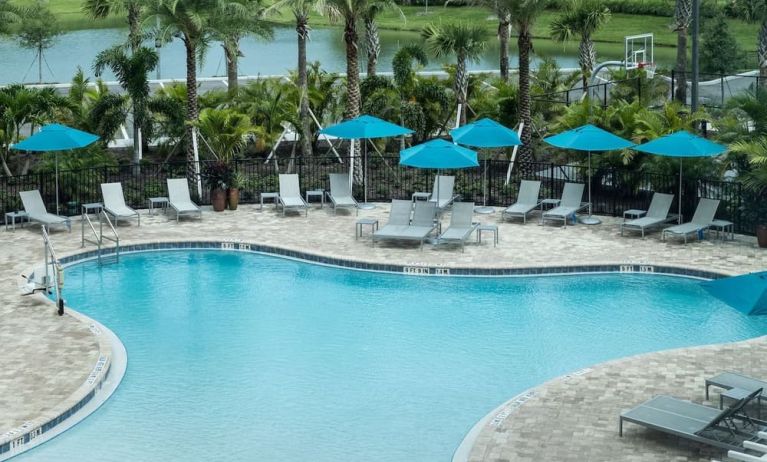 Outdoor pool with lounge seating at Home2 Suites By Hilton Cape Canaveral Cruise Port.