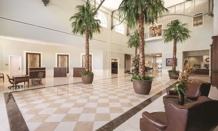 Hotel reception with lounge seating and workspace at Embassy Suites By Hilton Savannah.