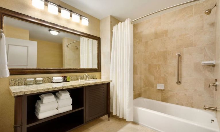 Private guest bathrooom with combined shower and tub at Embassy Suites By Hilton Savannah.