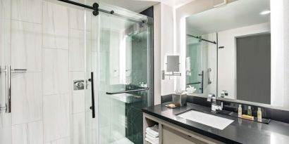 Private guest bathroom with shower and free toiletries at DoubleTree By Hilton Washington DC North/Gaithersburg.