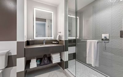 Private guest bathroom with shower and free toiletries at The Rose Hotel Chicago O’Hare, Tapestry Collection By Hilton.