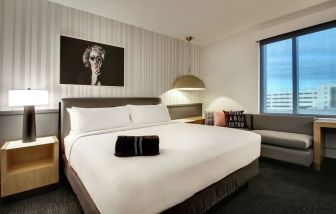 Day use room with sofa and work desk at The Rose Hotel Chicago O’Hare, Tapestry Collection By Hilton.