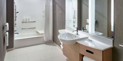 Private guest bathroom with combined shower and tub at 	SpringHill Suites Atlanta Northwest.