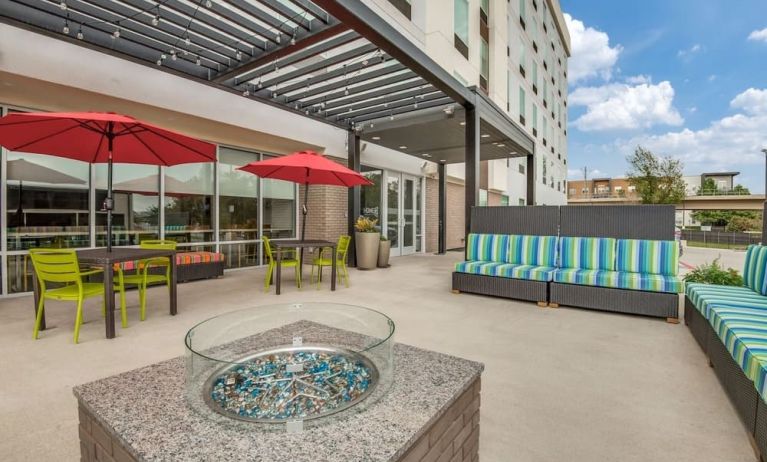 Hotel terrace with lounge seating and fire pit at Home2 Suites By Hilton Dallas Medical District Lovefield.