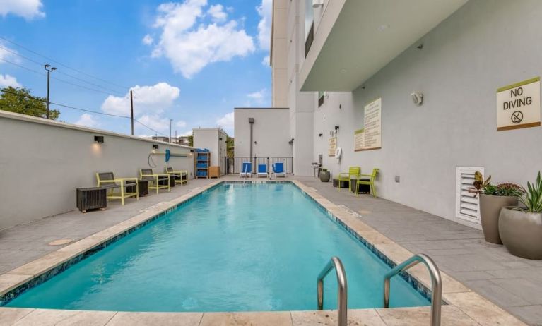 Outdoor pool with lounge chairs at Home2 Suites By Hilton Dallas Medical District Lovefield.