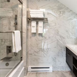 Private guest bathroom with combined shower and tub at SKYLARANNA Resort & Spa.