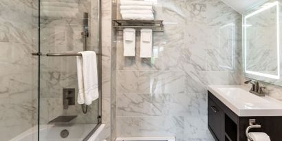 Private guest bathroom with combined shower and tub at SKYLARANNA Resort & Spa.