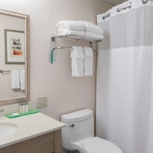 Private guest bathroom with shower and free toiletries at Sea Crest Beach Hotel.