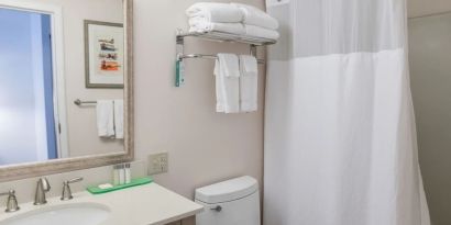 Private guest bathroom with shower and free toiletries at Sea Crest Beach Hotel.