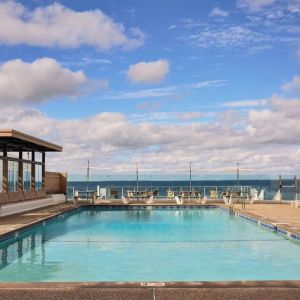 Outdoor pool with lounge chairs at Sea Crest Beach Hotel.