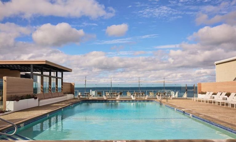Outdoor pool with lounge chairs at Sea Crest Beach Hotel.