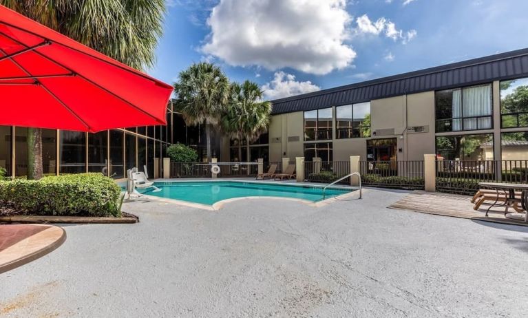 Hotel patio with lounge chairs and outdoor pool at Red Roof PLUS+ & Suites Houston - IAH Airport SW.