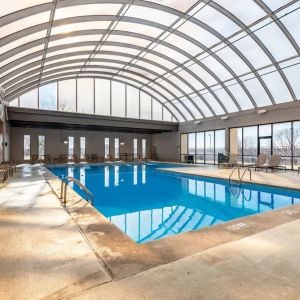 Relaxing indoor pool with lounge chairs at Wyndham Omaha.