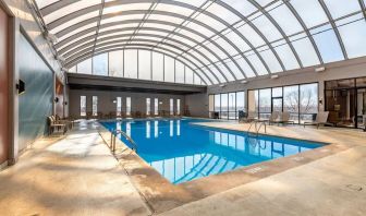 Relaxing indoor pool with lounge chairs at Wyndham Omaha.