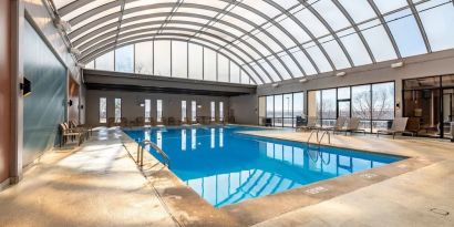 Relaxing indoor pool with lounge chairs at Wyndham Omaha.