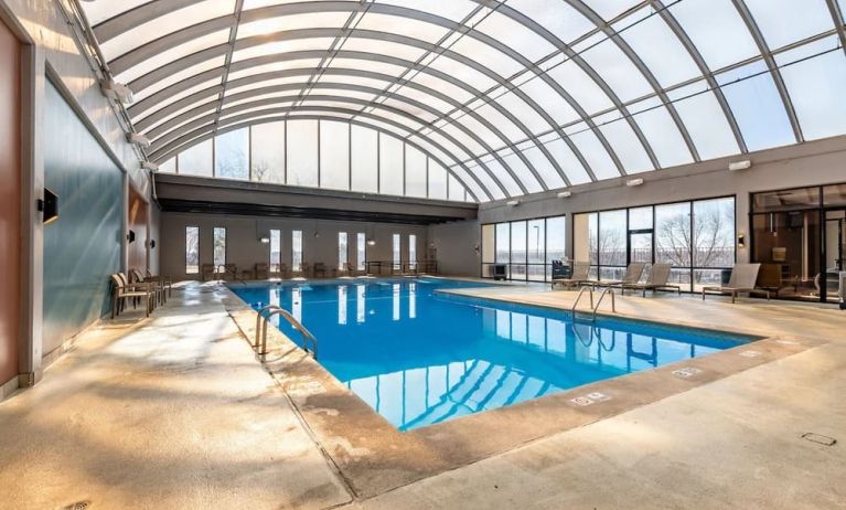 Relaxing indoor pool with lounge chairs at Wyndham Omaha.