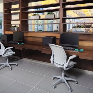 Business center with computers, printer and ergonomic chairs at Element Miami International Airport.