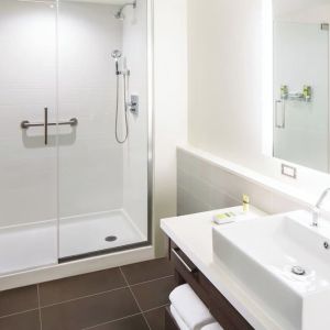 Private guest bathroom with shower and free toiletries at Element Miami International Airport.