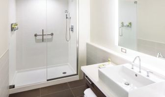 Private guest bathroom with shower and free toiletries at Element Miami International Airport.
