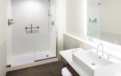 Private guest bathroom with shower and free toiletries at Element Miami International Airport.