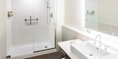 Private guest bathroom with shower and free toiletries at Element Miami International Airport.