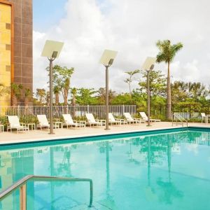 Outdoor pool with lounge chairs at Element Miami International Airport.