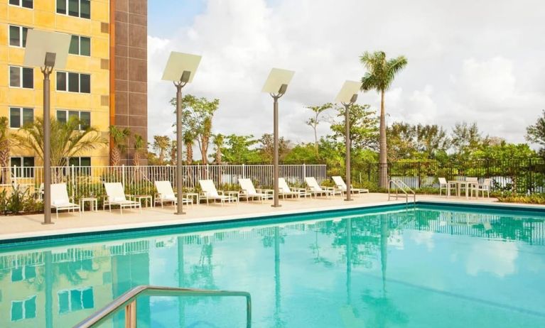 Outdoor pool with lounge chairs at Element Miami International Airport.