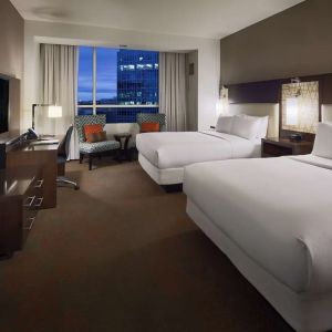 Day use twin room with workspace and lounge seating at Hilton Dallas/ Plano Granite Park.