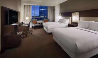 Day use twin room with workspace and lounge seating at Hilton Dallas/ Plano Granite Park.